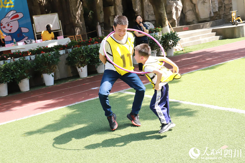 亲子呼啦圈接力比赛，家长眼明手快，孩子身手敏捷。李恭玉摄