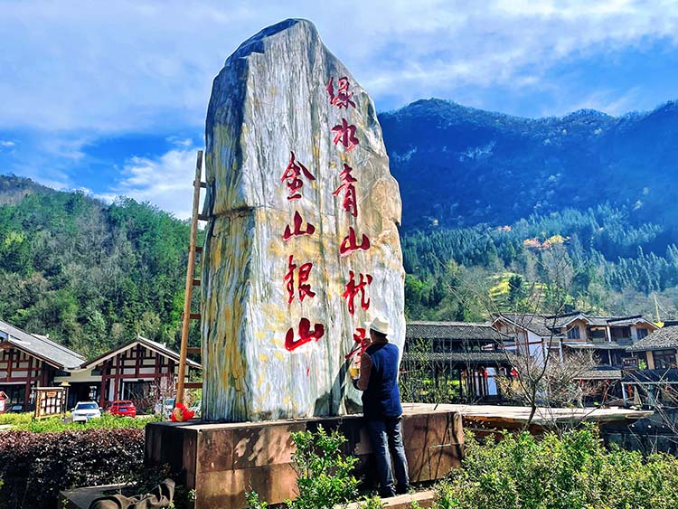 工人正在在村口给界碑涂色。利州区委宣传部供图