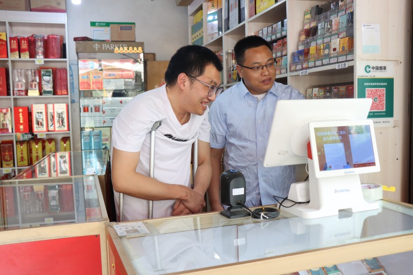 肖文正在教李磊使用智慧收银机。张远供图