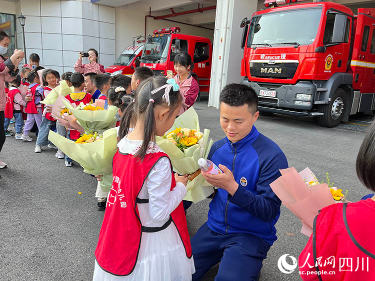 向消防叔叔獻花。劉璽攝