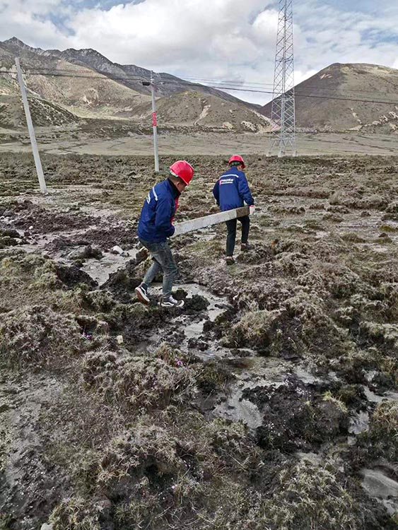 抬救援设备行走在沼泽地里。理塘县融媒体中心供图