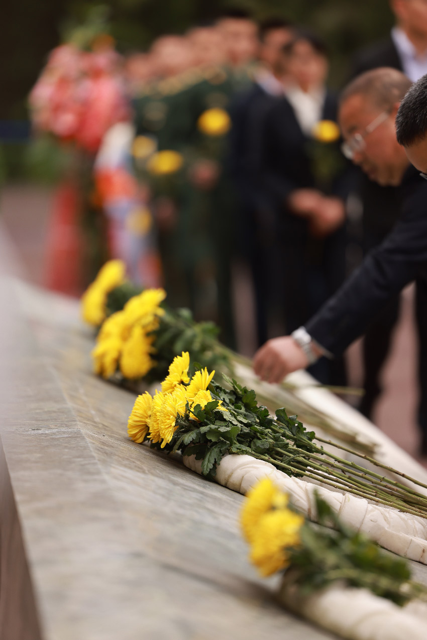 为遇难同胞敬献鲜花。汶川融媒体中心供图