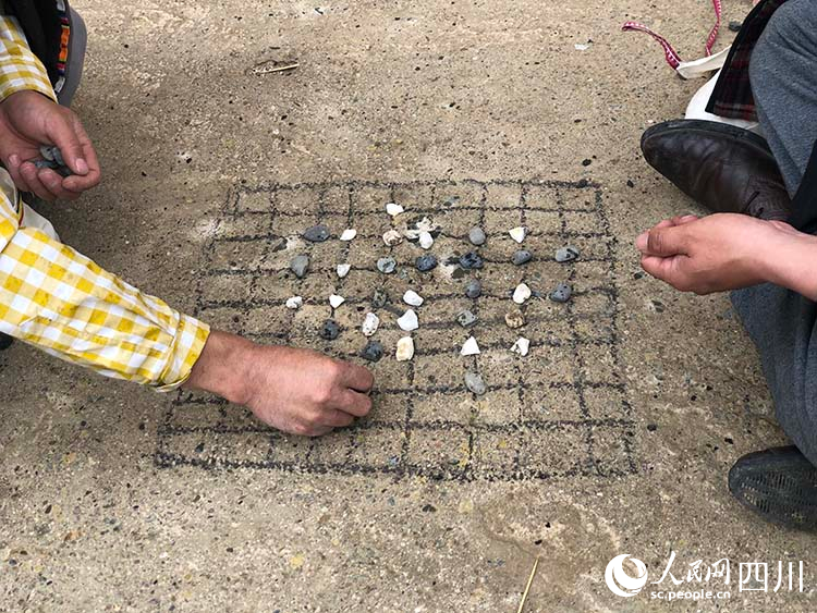 藏棋愛好者坐在地上下藏棋。麥拉攝