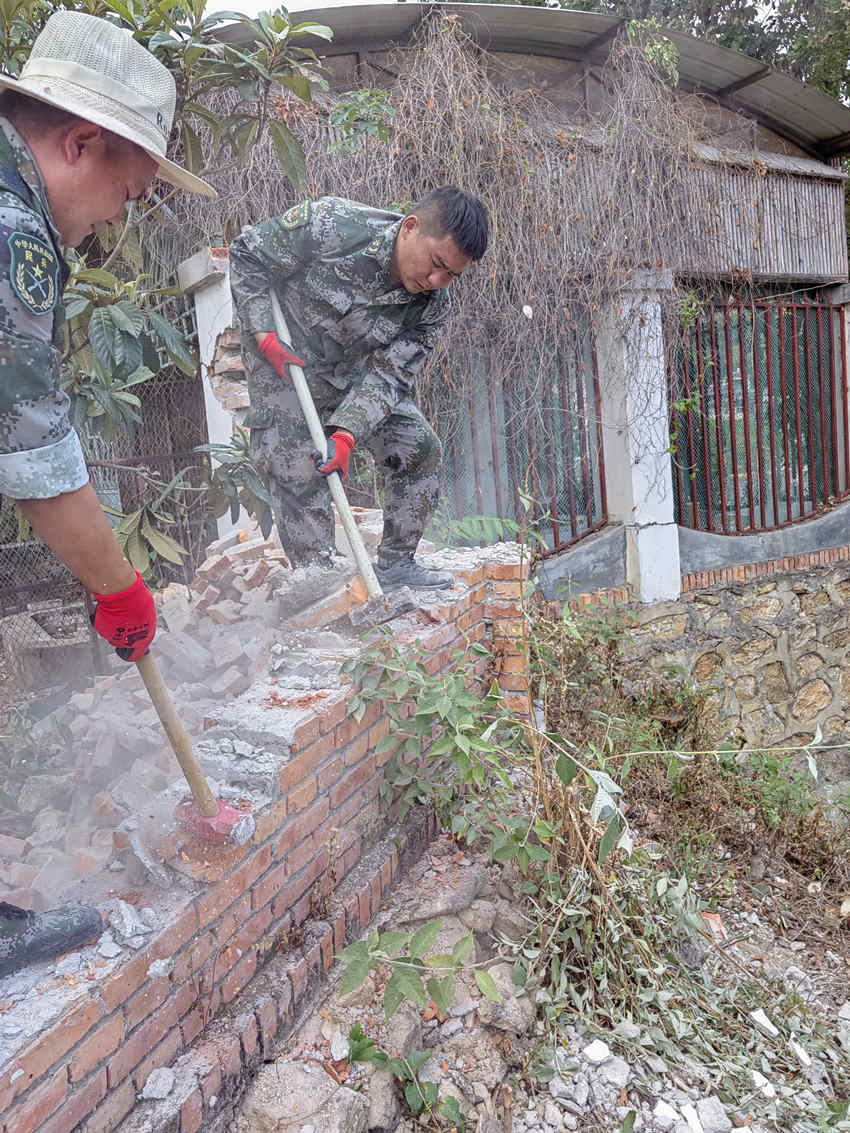 杨爱理（右一）在拆除危墙。陆军第77集团军某旅供图