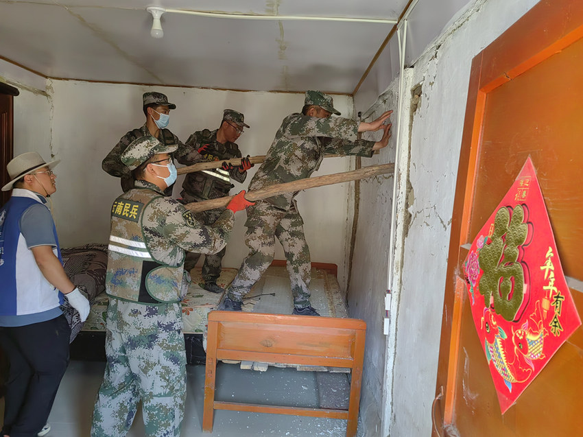 杨爱理（右一）在排除房屋安全隐患。陆军第77集团军某旅供图