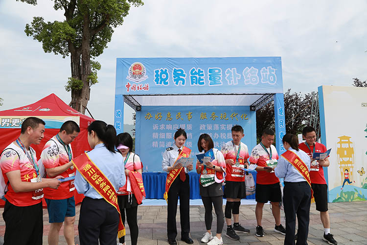 税务干部志愿者向参赛选手宣传税法。达州市税务局供图