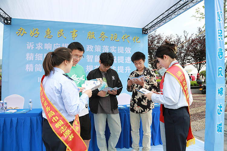 税务干部志愿者向市民宣传税法。达州市税务局供图