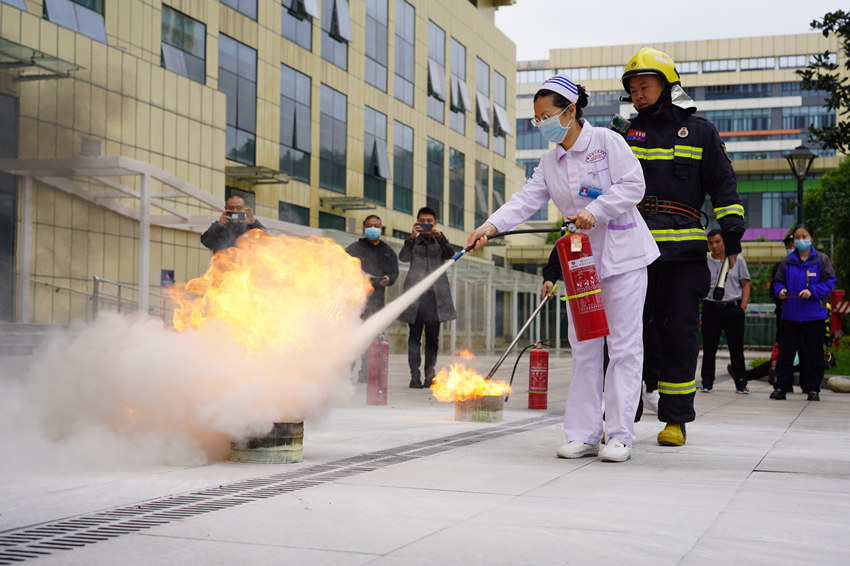 消防员指导医院职工学习使用干粉灭火器。雅安市消防救援支队供图
