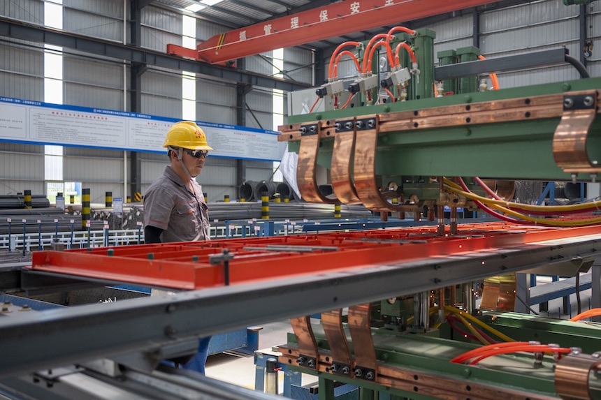 “智慧粱场”内，工人正在利用自动焊接生产线进行生产。成达万公司供图