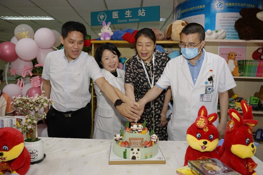 四川省腫瘤醫院黨委書記易群（左三）在病房為孩子慶祝節日。四川省腫瘤醫院供圖