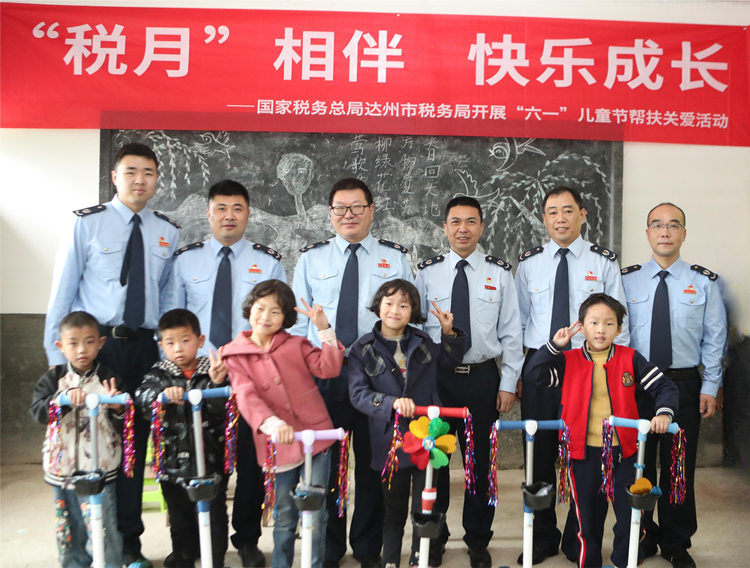 达州市税务局党委委员、副局长周宏一行为帮扶村儿童送来节日“惊喜”。陈镜霖摄