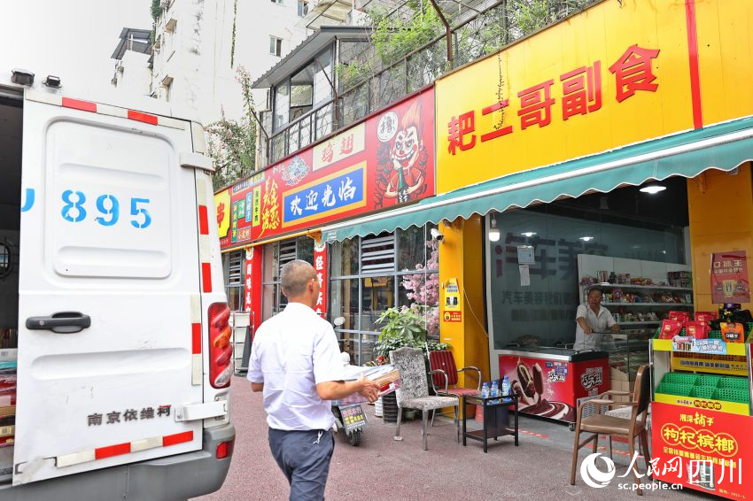 送货员李胜将货物搬到门口。杨千依摄