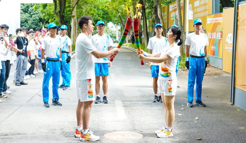 火炬手正在传递交接。成都大运会执委会供图