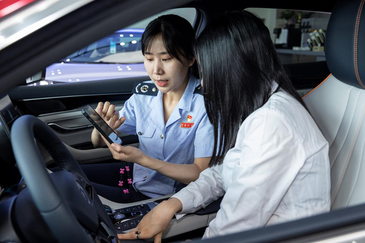 稅務干部在新能源車4S店向消費者介紹新能源汽車免征車輛購置稅政策。成都市稅務局供圖
