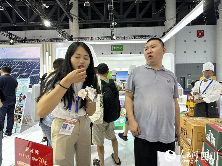 参展客商品尝甜皮鸭。人民网记者 王波摄
