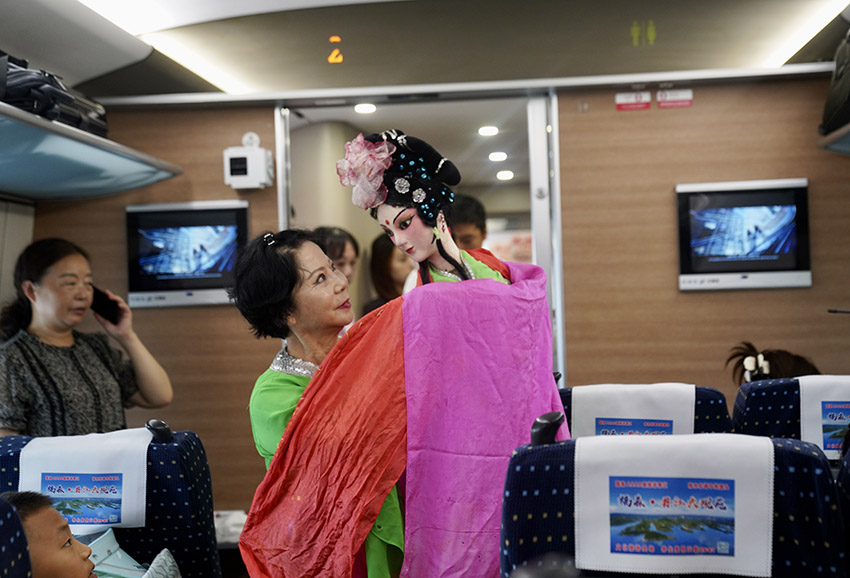 首发列车车厢内，乘客体验到川味浓厚的表演。中国铁路成都局集团公司供图