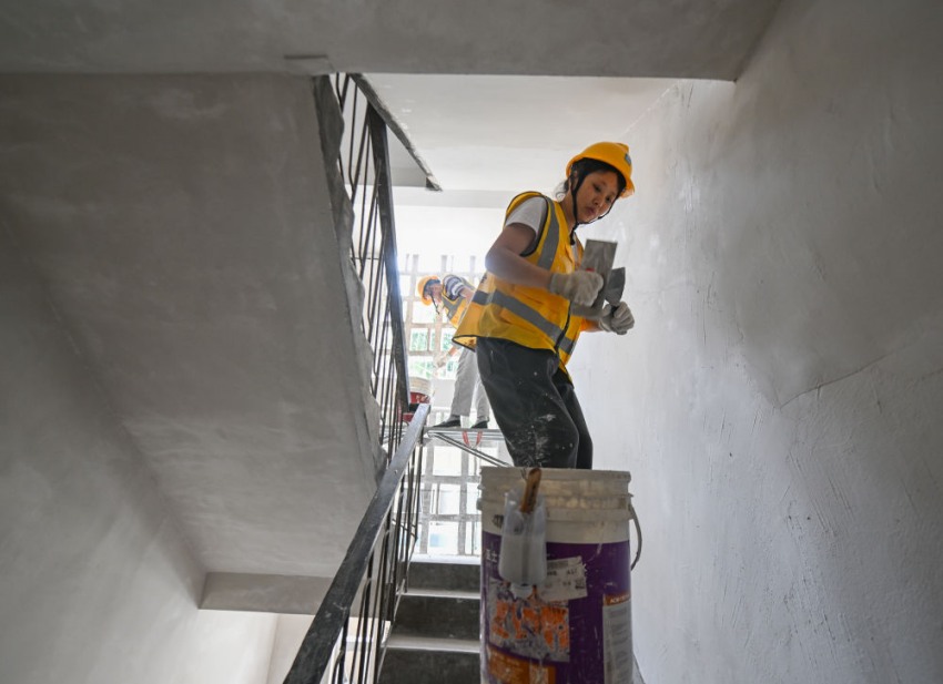 在四川省乐山市市中区海棠街道一处老旧小区改造工地，工人在楼道内抹灰。中建安装华西公司供图