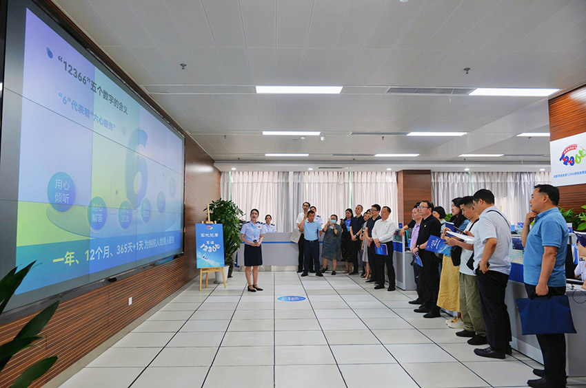 税务干部向参观代表们介绍热线咨询流程。四川省税务局供图