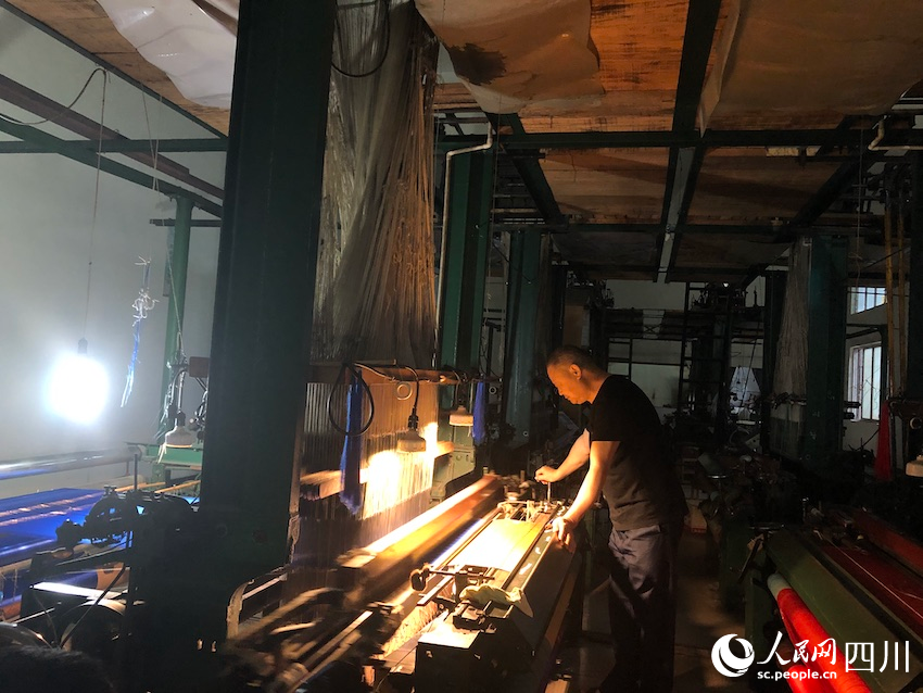 工人师傅正在操作织机。邓芸摄
