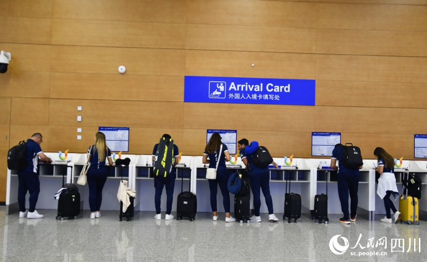 在成都天府国际机场，首批抵蓉的巴西代表团成员填写入境卡。人民网记者 王洪江摄