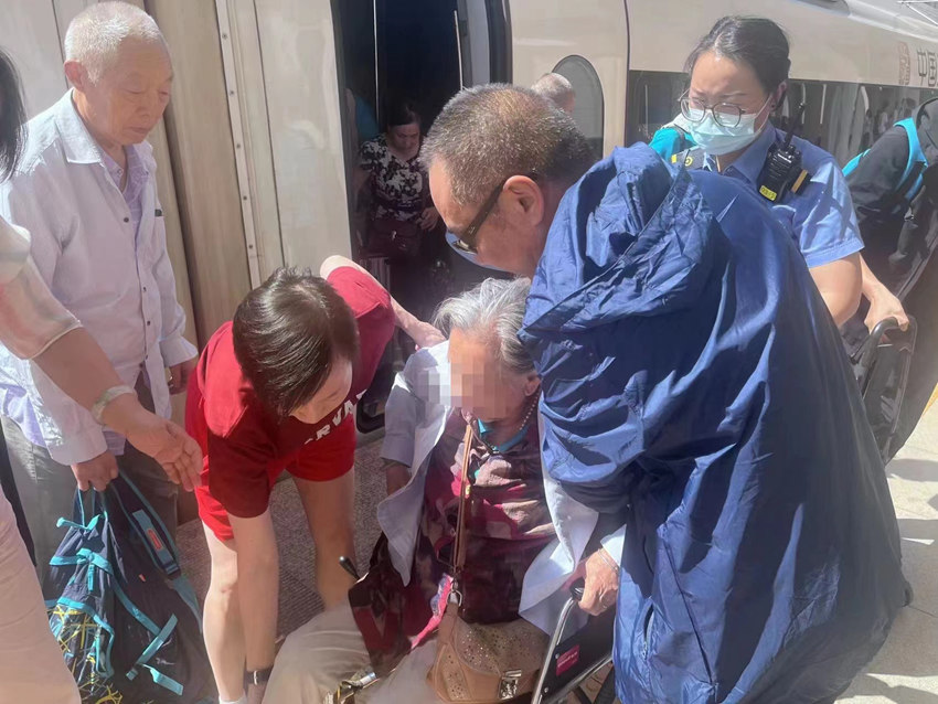 王瑜和车组人员一起，把李奶奶送下车。资阳市委宣传部供图