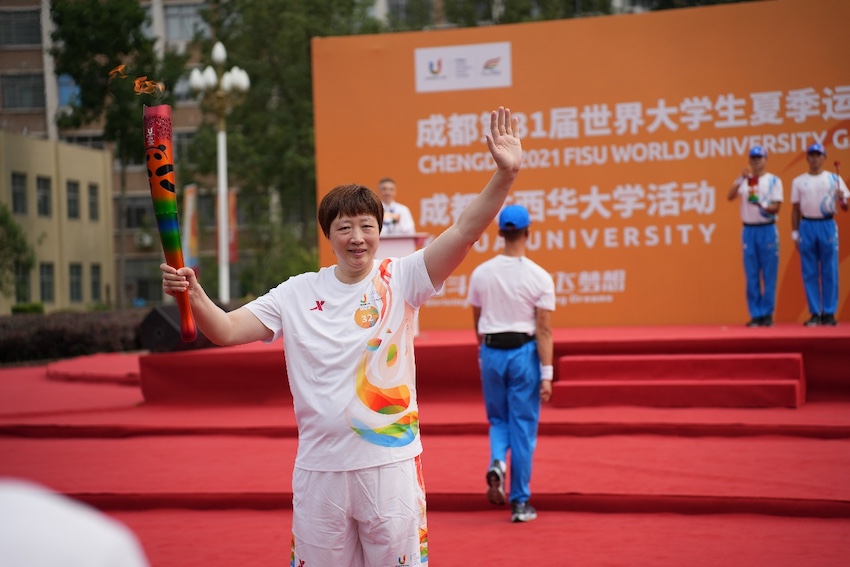 活动首棒火炬手、前中国女排队员、雅典奥运会女排冠军队员陈静高擎火炬，开始了火炬在西华大学的传递。王舒摄