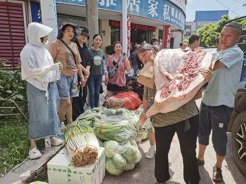 骆亚（左二）送来猪肉和蔬菜。周元利摄