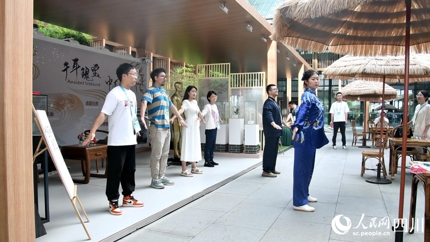 展示区工作人员正在带领参观者体验八段锦。人民网记者 王洪江摄