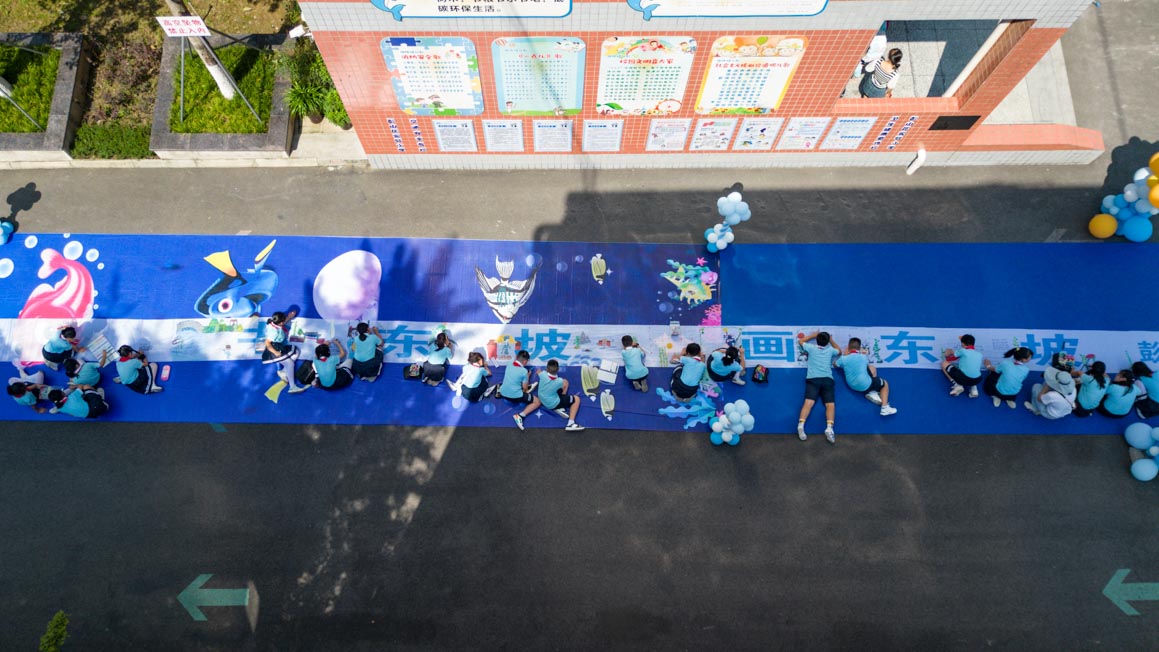 眉山市彭山区实验小学同学们在百米画卷上创作。翁光建摄