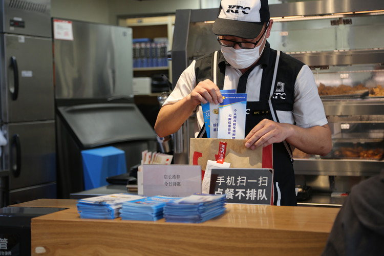 餐饮店工作人员将装有税惠政策的“幸福餐”送达客户。达州市税务局供图