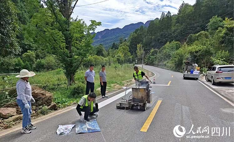 工作人員正在鋪設徒步游交通標線。王春波攝