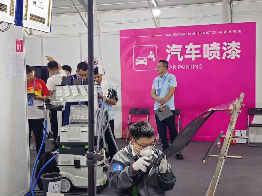 汽车喷漆项目，选手需要运用合适的技术和流程对汽车工件上的损伤进行喷漆修复，图为四川团选手何名在赛场完成比赛。四川人社供图