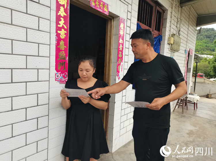 文江镇胜利村纪委书记正在向群众发放“廉情连心卡”。熊玉婷摄