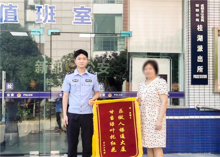 桂湖派出所民警黃宇接受群眾錦旗。新都公安供圖