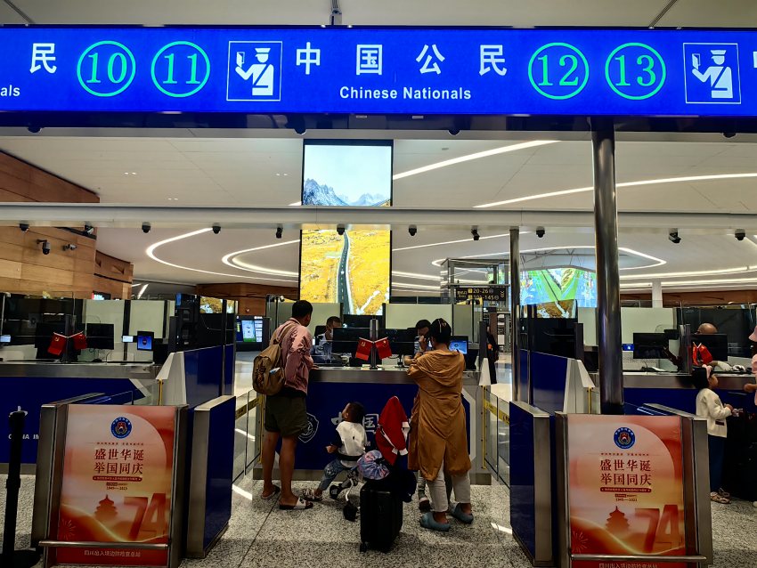 移民管理警察为出入境旅客办理通关手续。成都边检供图