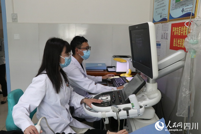 金川县人民医院超声科朱晓娟与徒弟正在为患者做彩超。 人民网记者 王洪江摄