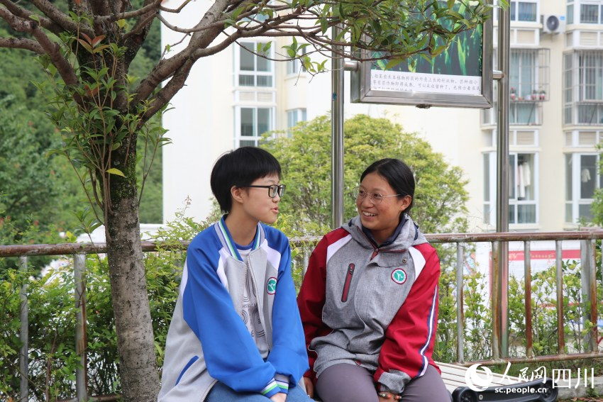 高二1班的蘇拉拉木（右）與同學（左）正在操場上愉快地聊天。李露萍 攝