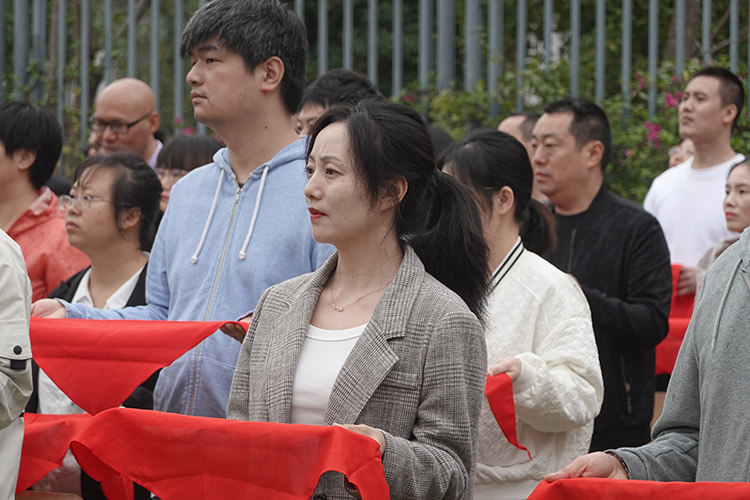 家长手捧红领巾准备给孩子佩戴。高新区公园小学供图