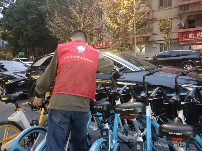 社区志愿者帮助规范共享单车停放。受访者供图