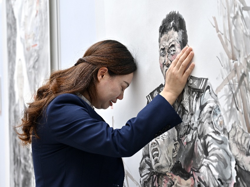 蒋久华妹妹蒋久芬在哥哥画像前 四川省公安厅供图