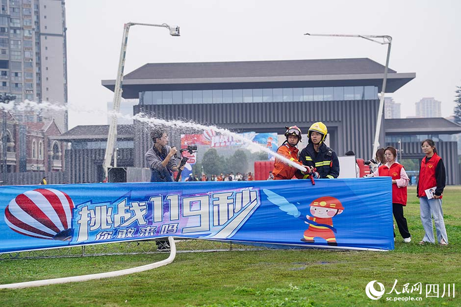 活動現場群眾體驗消防水槍。翁光建攝