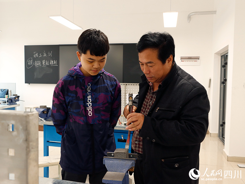 钳工实训中老师为学生演示操作技巧。勾璇摄