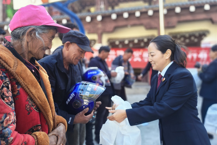 为联谊亲戚送去安全头盔。得荣县人民检察院供图