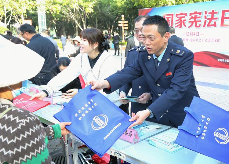 税务干部向市民送上宪法宣传资料。米易县税务局供图