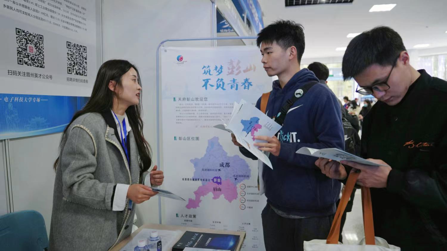 毕业生向工作人员了解岗位信息。徐伊妮摄