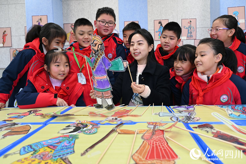老师指导学生学习皮影制作和表演技艺。兰自涛摄
