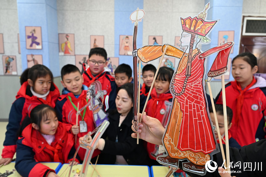 老师指导学生学习皮影制作和表演技艺。兰自涛摄
