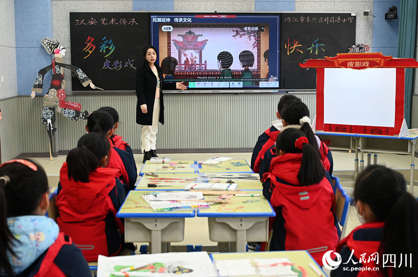 老师指导学生学习皮影制作和表演技艺。兰自涛摄