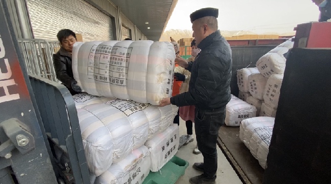 甘肃省临夏州东乡族自治县经济开发区物资卸货点，工作人员正在卸货。四川省应急管理厅供图