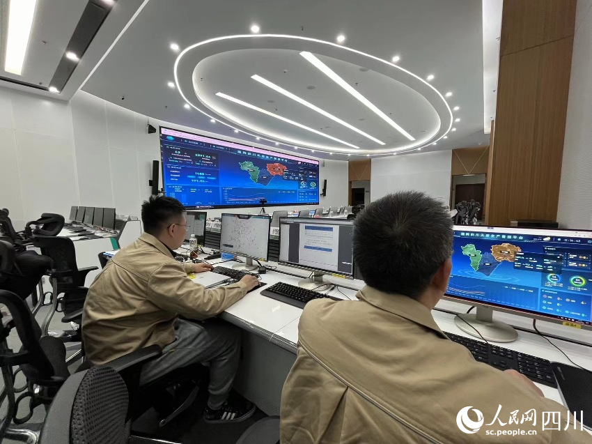 在國網天府新區供電公司供電服務指揮大廳內，值班人員正在智慧保電指揮系統上查看當前電網負荷情況。陳雨明攝